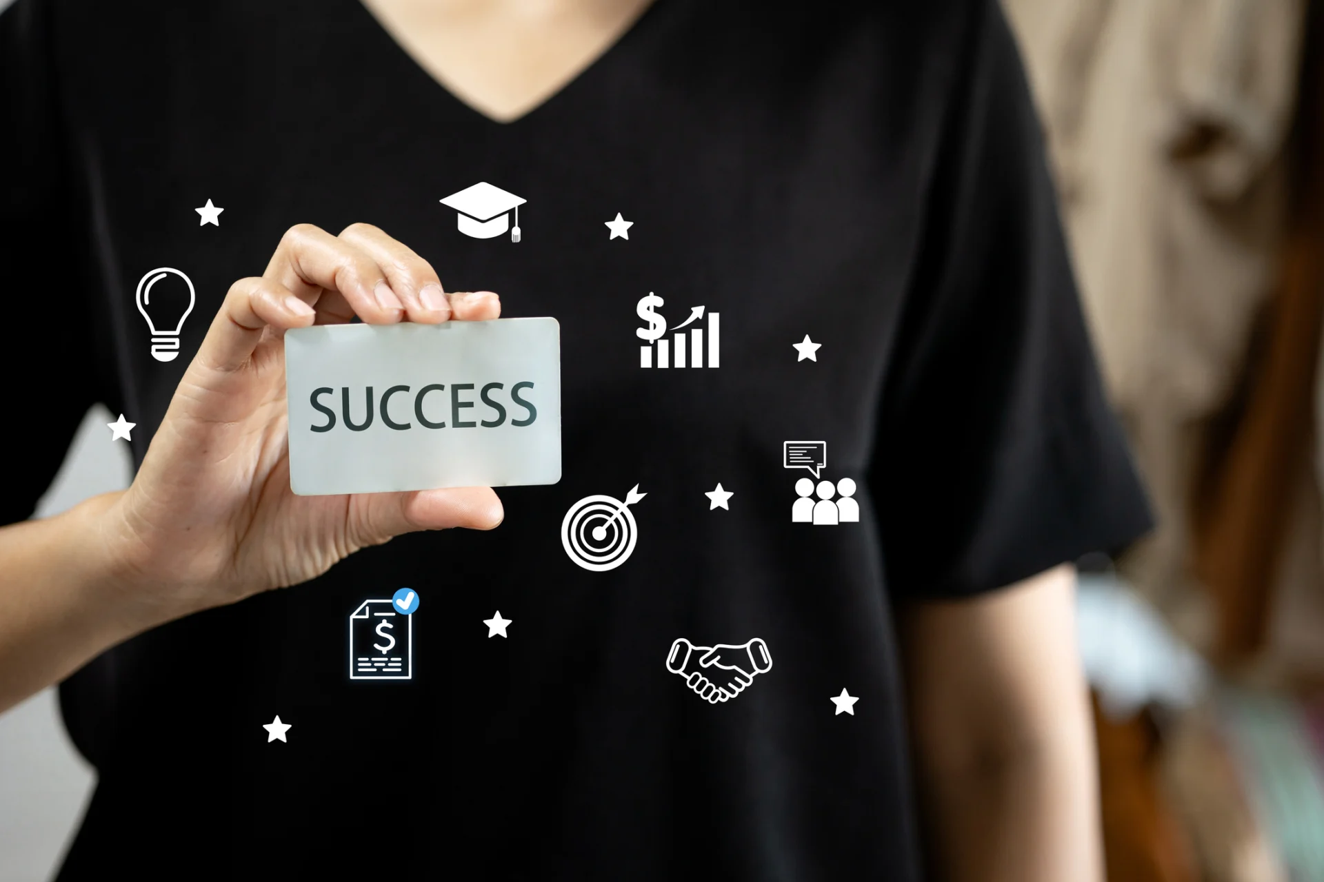 Person holding "Success" card with icons.